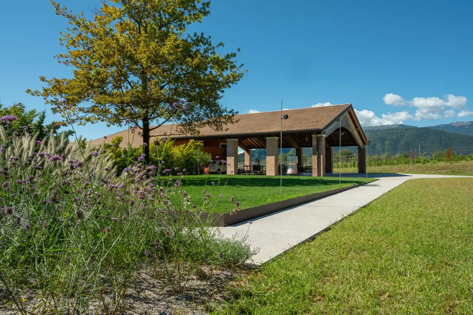 Fassade des Weinguts Fasol Menin mit blühendem Balkon und Garten